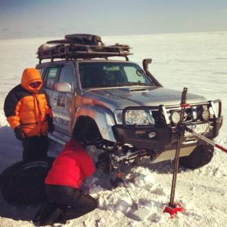 Машина поднято с помощью хайджека на льду Берингова моря